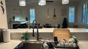 A kitchen with a sink, hanging guitars, and pendant lights. - 生日和结婚与节日派对
Birthday, Wedding, and Holiday Parties (Rancho Cucamonga)
