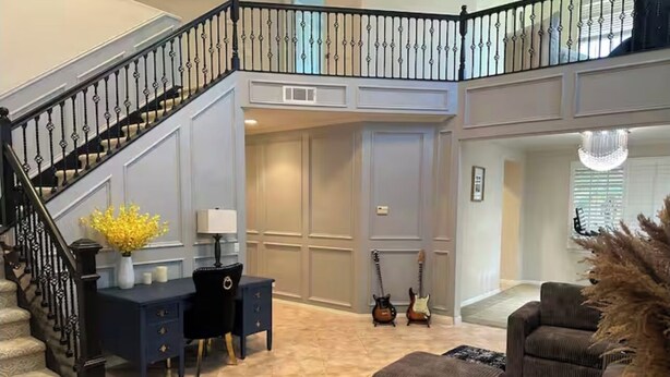 A spacious living area with a staircase, a dark blue desk, two guitars, and a large sectional sofa. - 生日和结婚与节日派对
Birthday, Wedding, and Holiday Parties (Rancho Cucamonga)