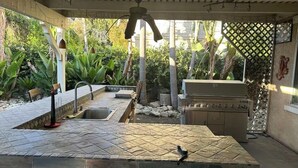 An outdoor kitchen area with a countertop, sink, and grill. - 生日和结婚与节日派对
Birthday, Wedding, and Holiday Parties (Rancho Cucamonga)