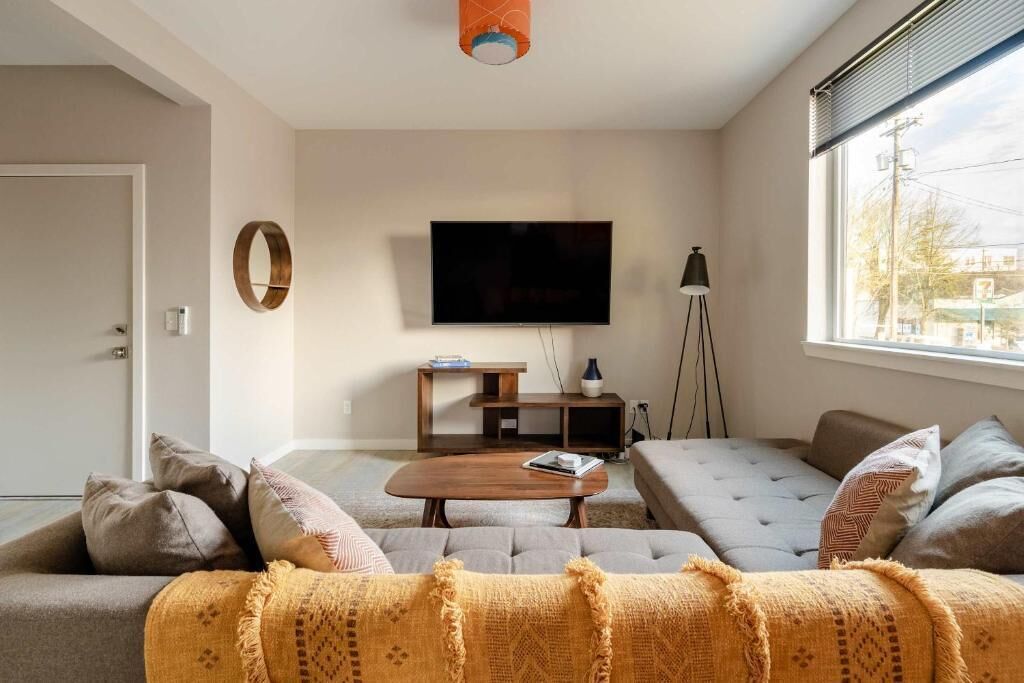Een woonkamer met een bank, een salontafel, een televisie en een lamp.
