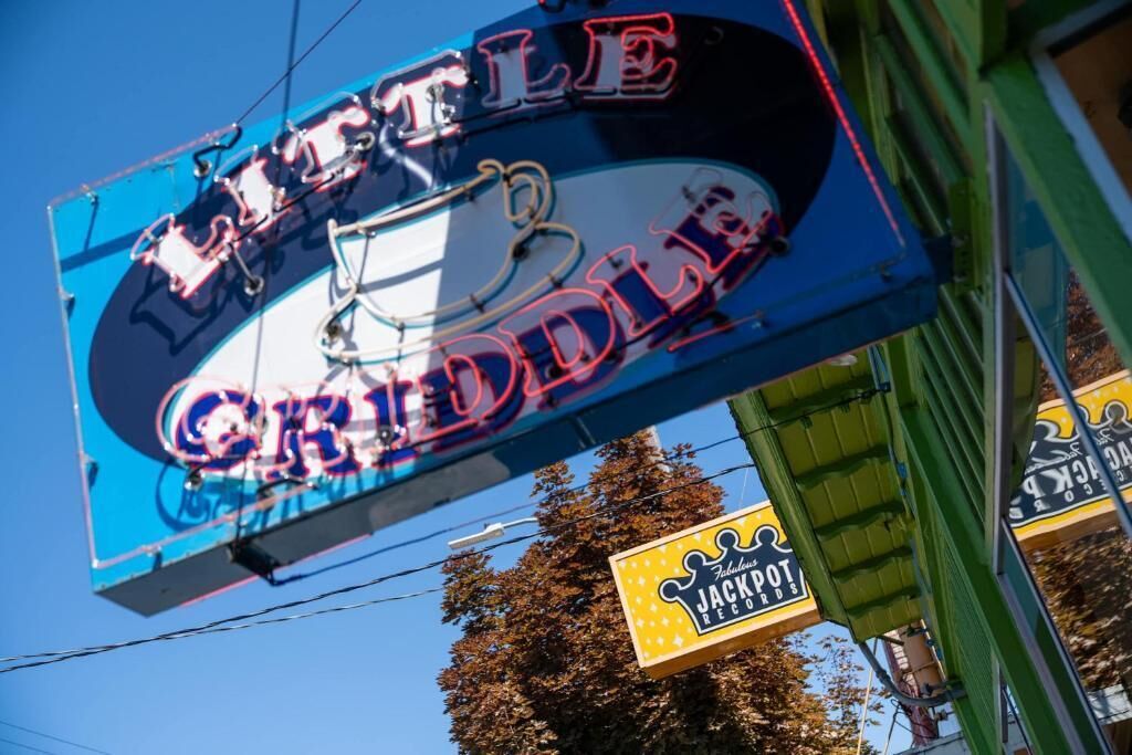 Um letreiro de neon para 'Little Griddle' com um desenho de bicicleta.