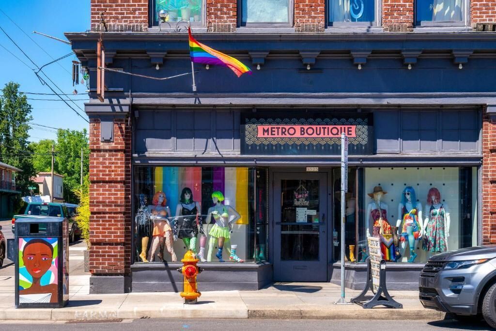 A storefront with a 'METRO BOUTIQUE' sign, mannequins in the window, and a fire hydrant on the sidewalk.