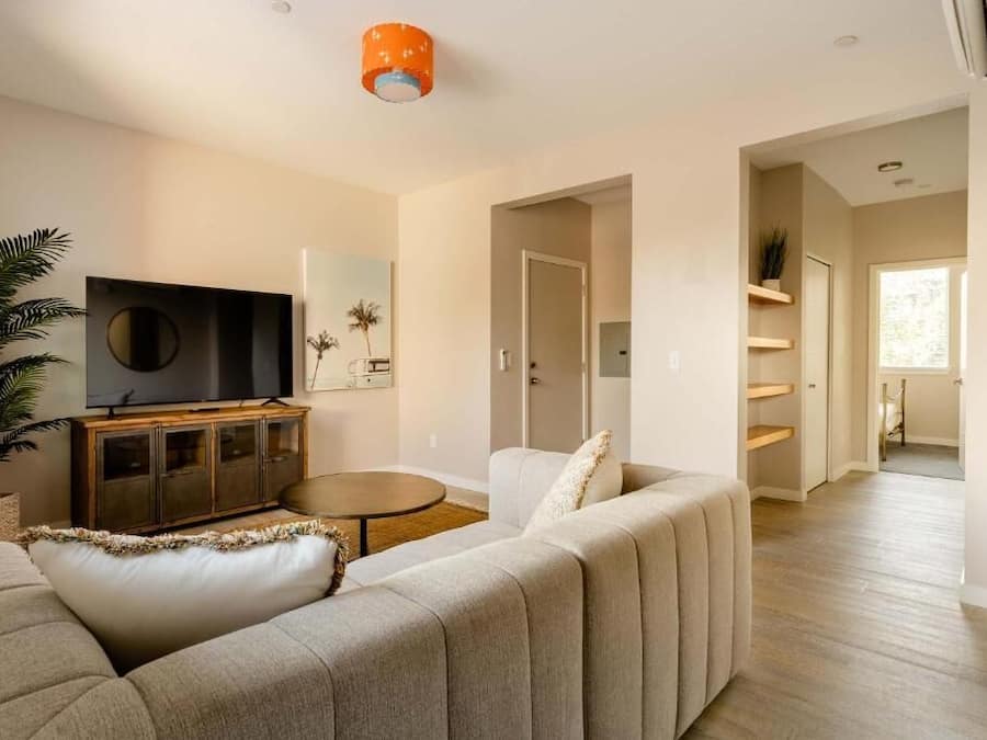 A modern living room with a sofa, TV, and a dining table.