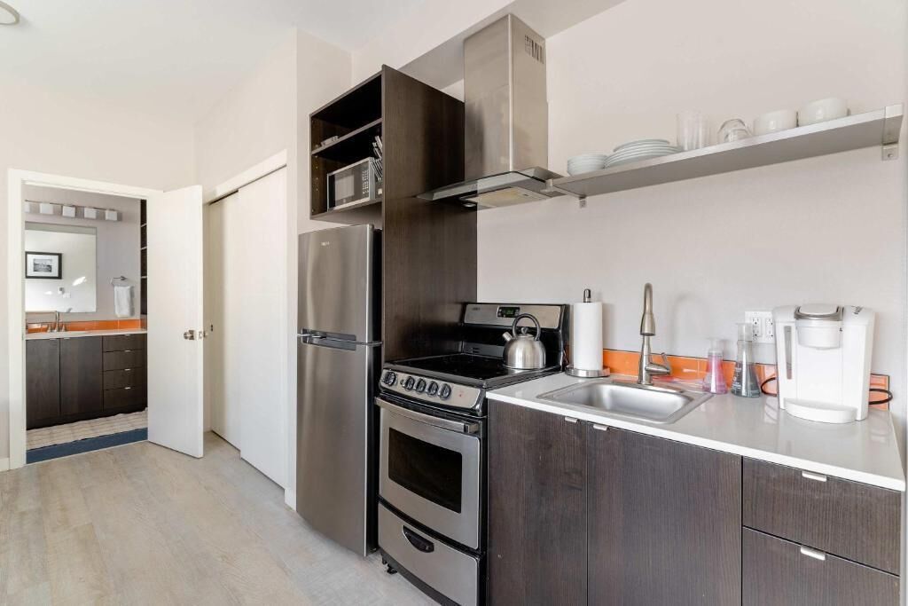 Una cocina moderna con electrodomésticos de acero inoxidable, horno integrado y microondas.
