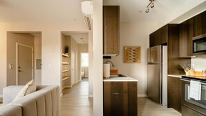 Una cocina moderna con armarios de madera oscura, electrodomésticos de acero inoxidable y una isla central.