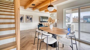 Een modern interieur met een houten plafond, een ronde eettafel met stoelen en een groot raam.