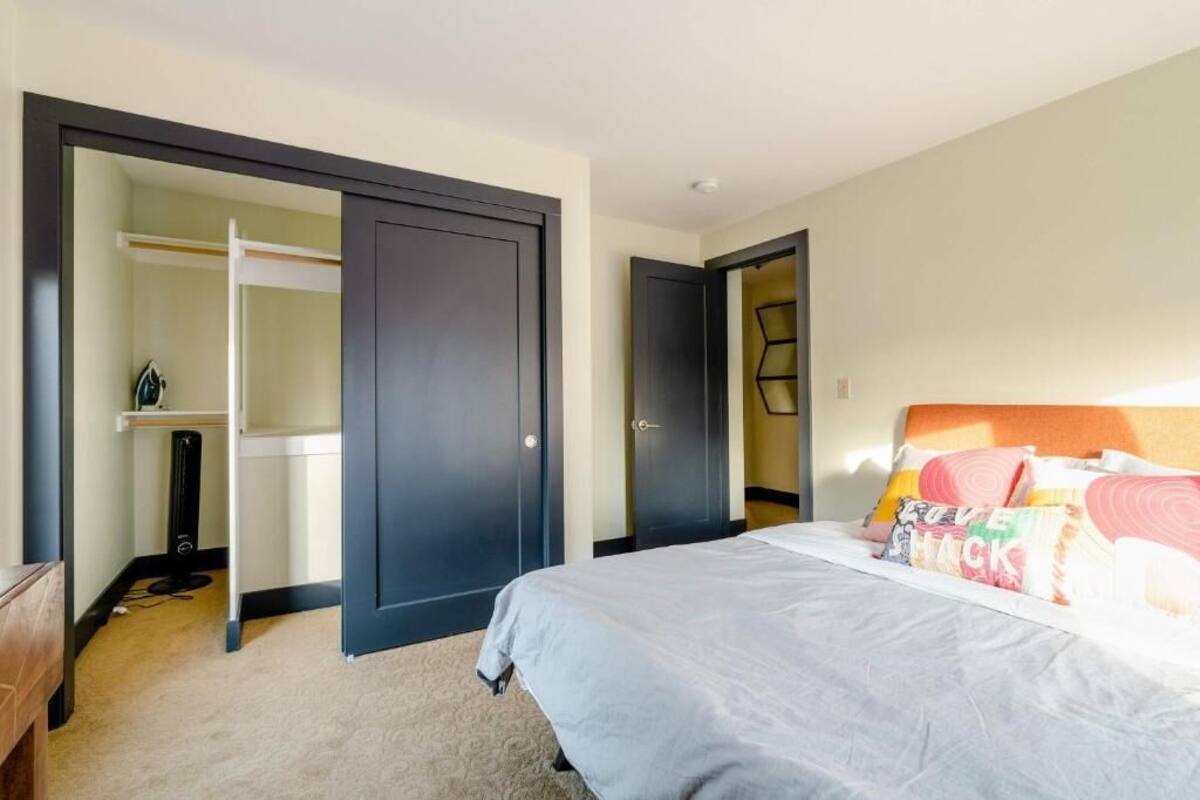 Una habitación de hotel con cama, armario y ropero.