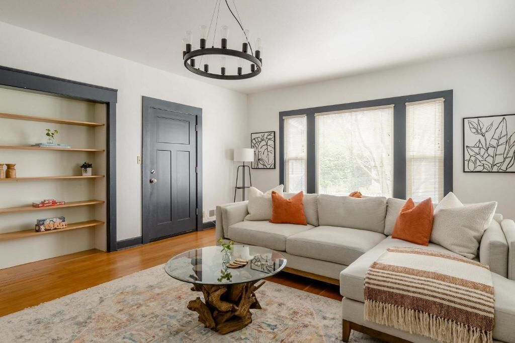 A living room with a sofa, coffee table, and shelving unit.