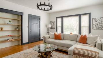A living room with a sofa, coffee table, and shelving unit.