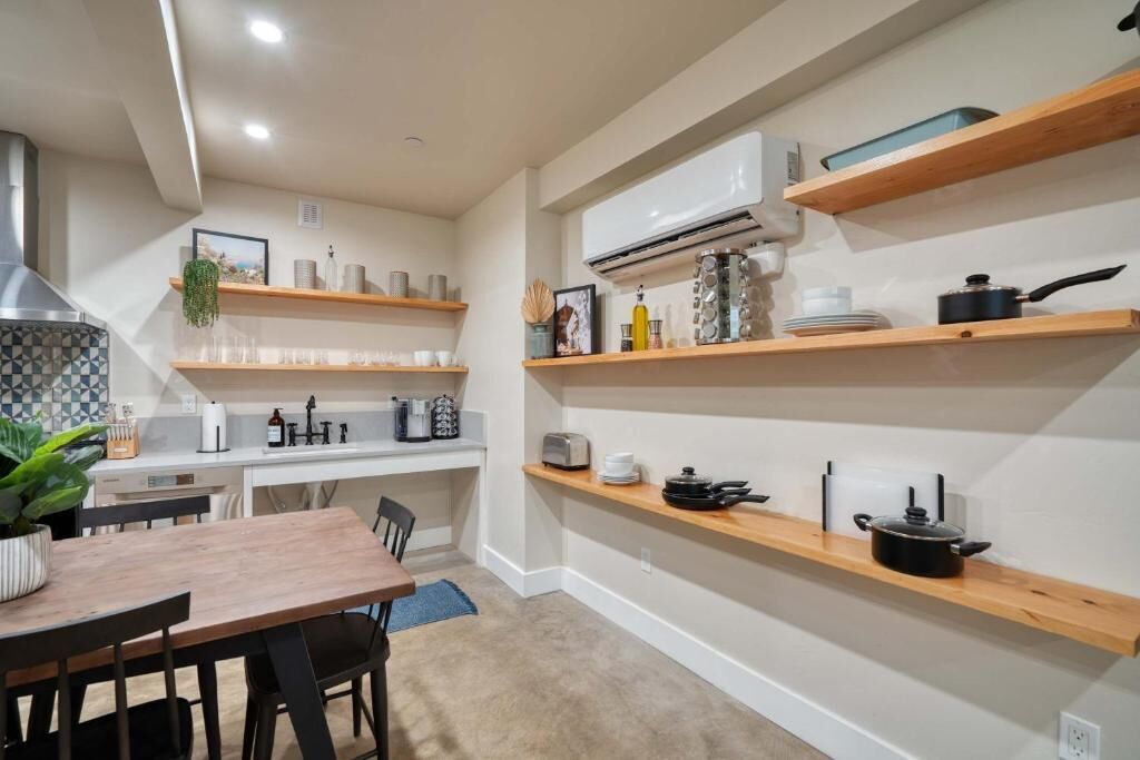 A compact kitchen with built-in shelves, a dining area, and a central island.