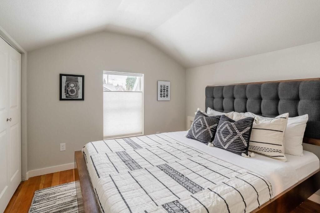 A bedroom with a bed, a window, and a door.