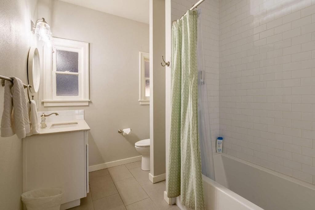 Une salle de bain avec des toilettes, un lavabo et un rideau de douche.