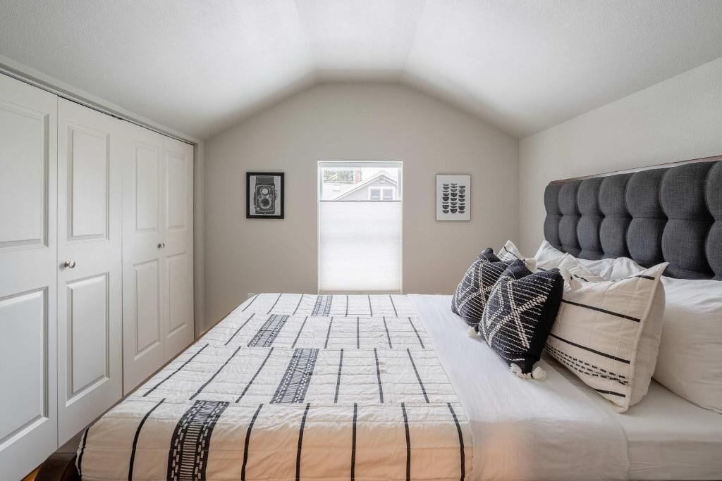 Een slaapkamer met een bed, een raam en een deur.