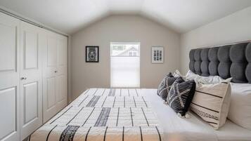 Un dormitorio con una cama, una ventana y una puerta.
