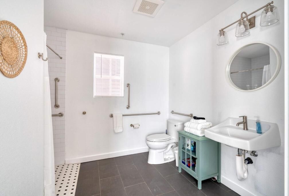 Une salle de bain comprenant des toilettes, un lavabo et un espace douche.