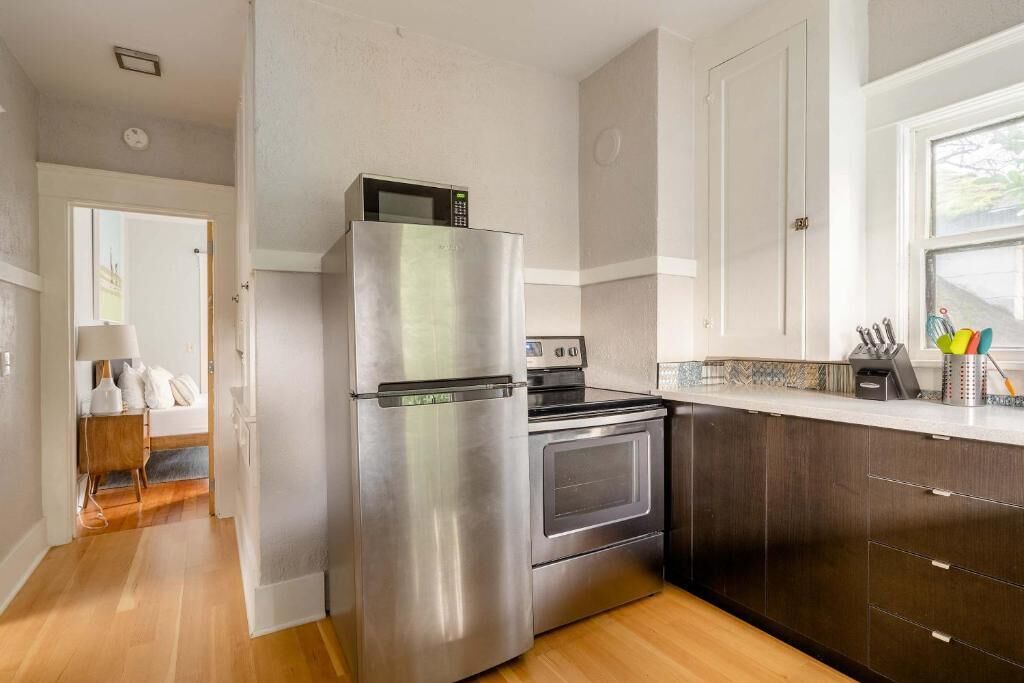 A kitchen with a stainless steel refrigerator, oven, and microwave.