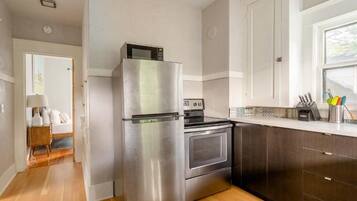A kitchen with a stainless steel refrigerator, oven, and microwave.