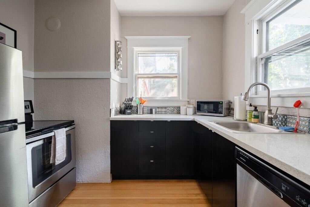 A kitchen with a stove, oven, microwave, sink, and dishwasher.
