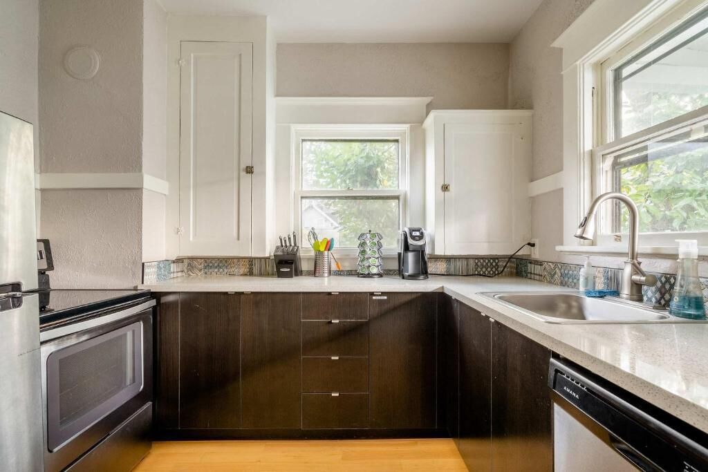 A kitchen with dark wood cabinets, a stainless steel sink, and a window providing natural light.