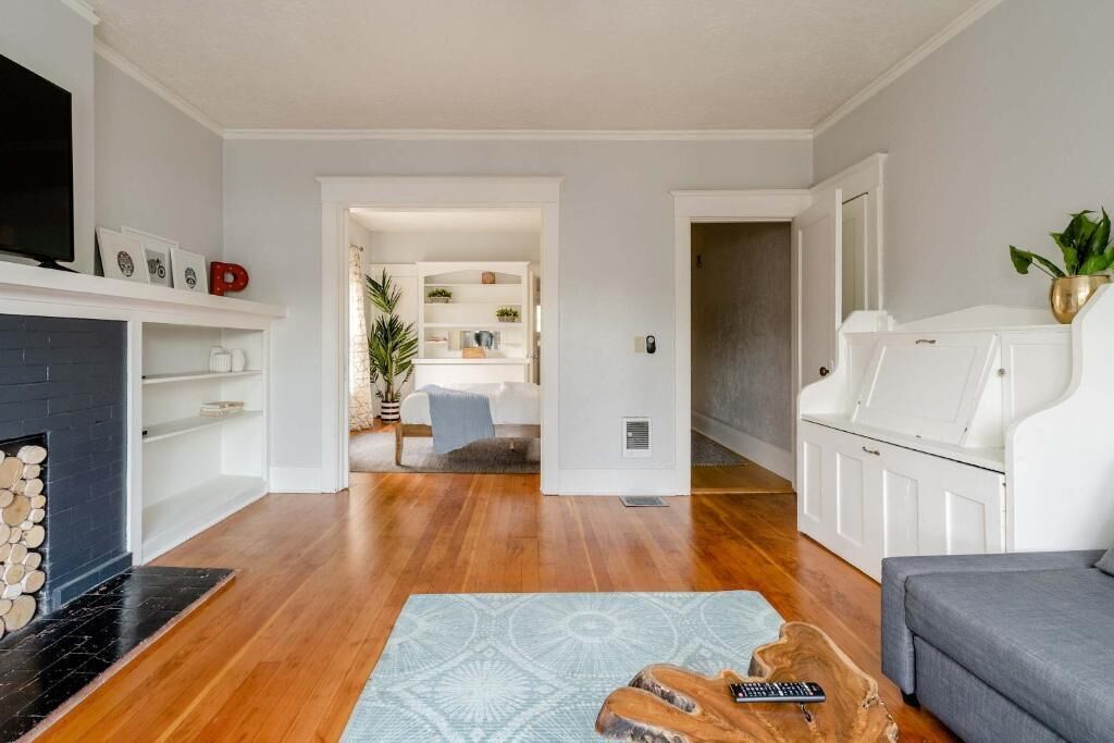 A living room with a fireplace, a sofa, a coffee table, and a television.