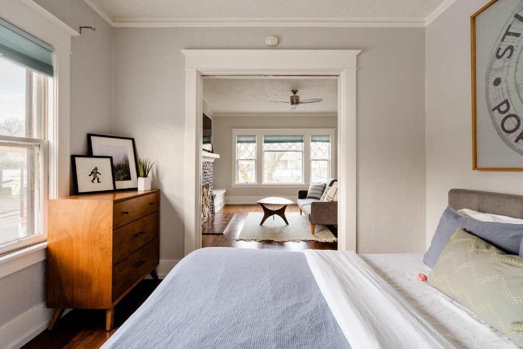 Une chambre à coucher avec un lit, une commode et une vue sur une autre pièce.