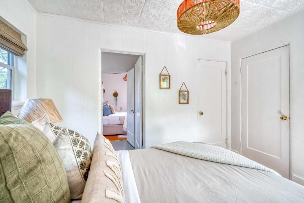 A bedroom with a bed, a door, and a window.