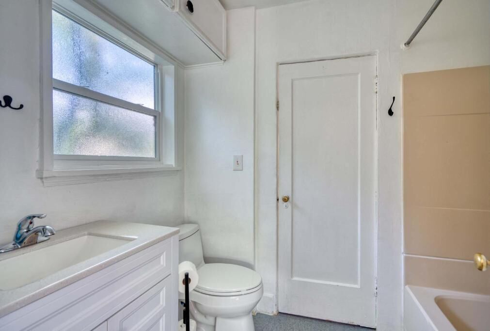 A bathroom with a white sink, toilet, and bathtub.