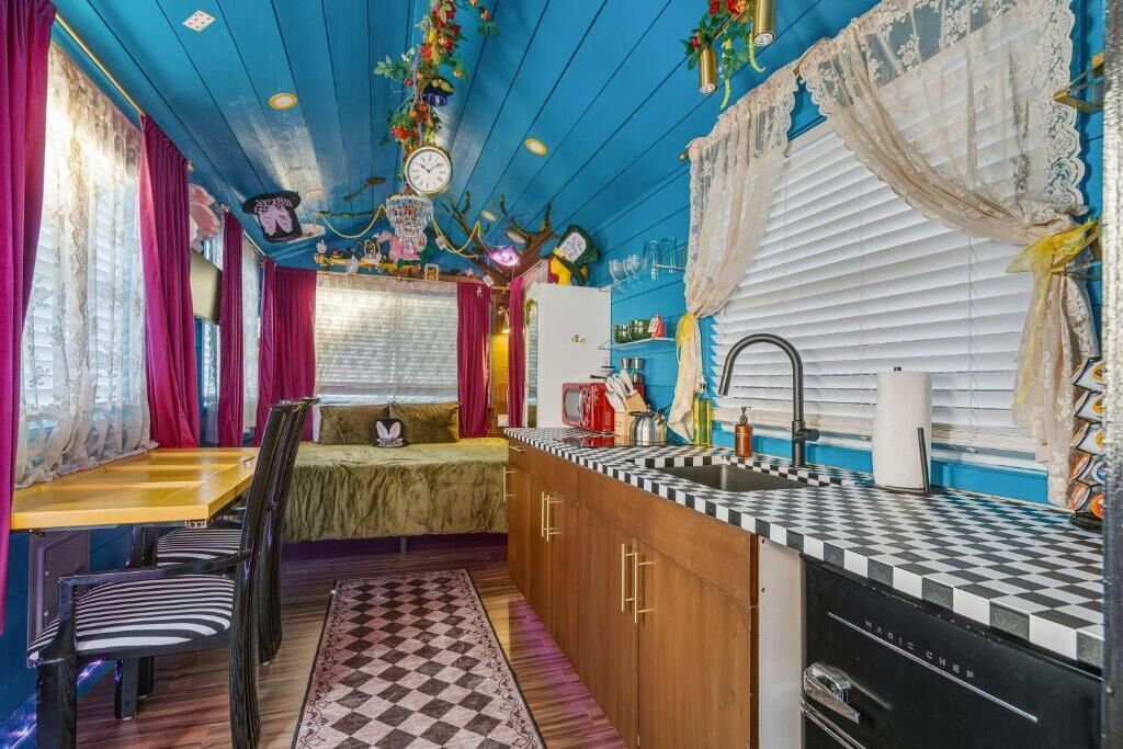 A compact kitchen with a checkered countertop, a sink, and a refrigerator.