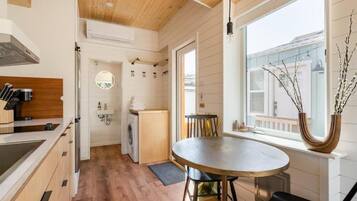 Une cuisine moderne avec un plancher en bois, un coin repas avec une table ronde et une vue par la fenêtre.