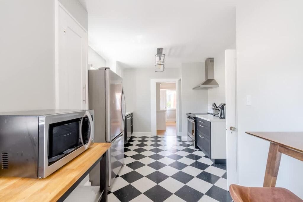 Una cucina con microonde, frigorifero e piano cottura.