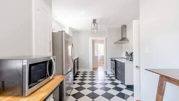 Una cocina equipada con microondas, refrigerador y estufa.