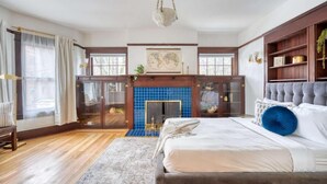 Um quarto com uma cama grande, lareira e vista para o exterior.
