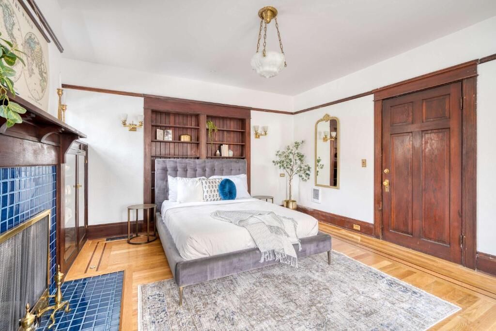 A bedroom with a bed, a dresser, a mirror, and a door.