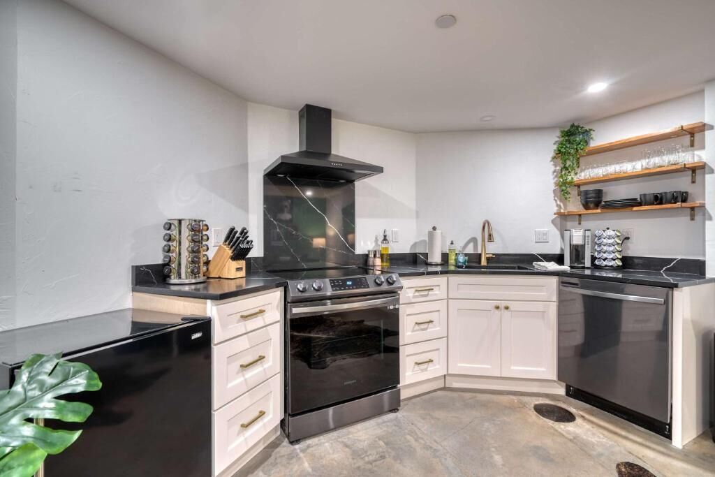 A modern kitchen with a built-in oven, a stove, and a dishwasher.