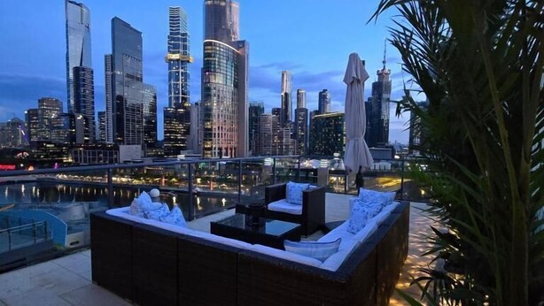 A rooftop lounge with a city skyline view, outdoor seating, and a water feature. - Charming 2-bedroom Apartment in Central Melbourne (Melbourne)