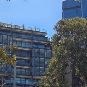 Un edifici d'edificis amb grans finestres i balcons, envoltat d'arbres.