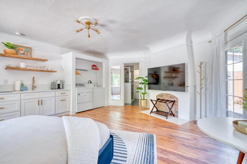 A spacious living area with a kitchen, a dining table, and a TV.