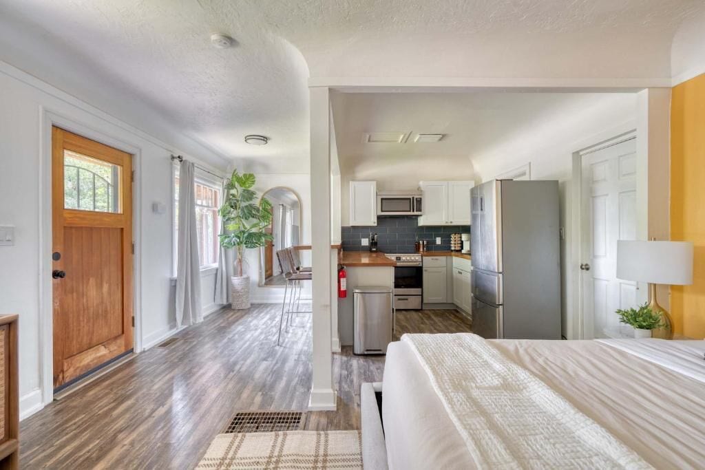 A modern kitchen with white cabinets, a microwave, and a refrigerator.