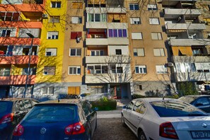 A multi-story residential building with balconies, parked cars, and a visible entrance. - Holiday apartment with air conditioning and washing machine (Pula)