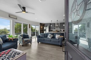 A modern living room with a sofa, a coffee table, and a ceiling fan.