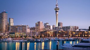 A city skyline with a prominent tower, a marina with boats, and various buildings. - Luxury 2-Bed Marina Apartment Pool, Spa & Gym (Auckland City)
