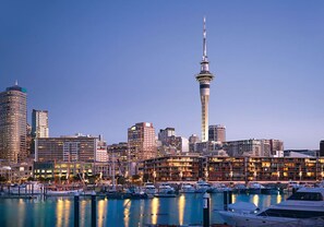 A city skyline with a prominent tower, a marina with boats, and various buildings. - Luxury 2-Bed Marina Apartment Pool, Spa & Gym (Auckland City)