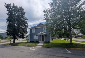 A residential house with a front porch, a driveway, and a street view.