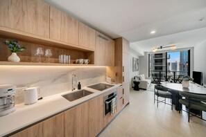 Eine moderne Küche mit Holzausstattung, einem eingebauten Backofen und einem Essbereich mit Tisch und Stühlen.