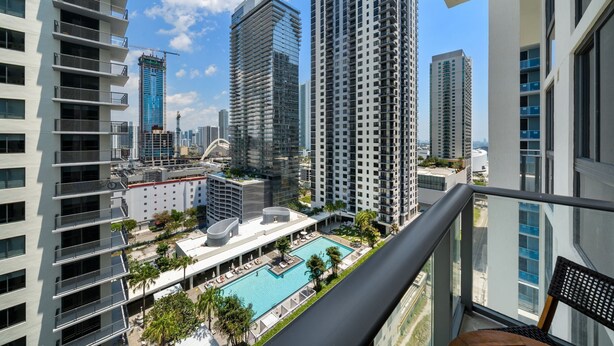 A high-rise building with a rooftop pool and a view of other high-rise buildings. - Crosby Miami WTC 1BR/1BA Cool Residence #2210 (Miami)