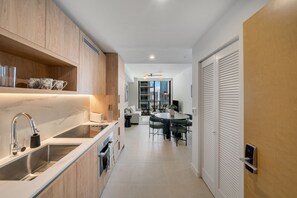 Eine moderne Küche mit Einbauofen, Spüle und Essbereich mit rundem Tisch und Stühlen.
