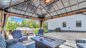 A covered patio with outdoor furniture, a fire pit, and a view of a house. - Carolina Meadows w/ Hot tub (Weaverville)