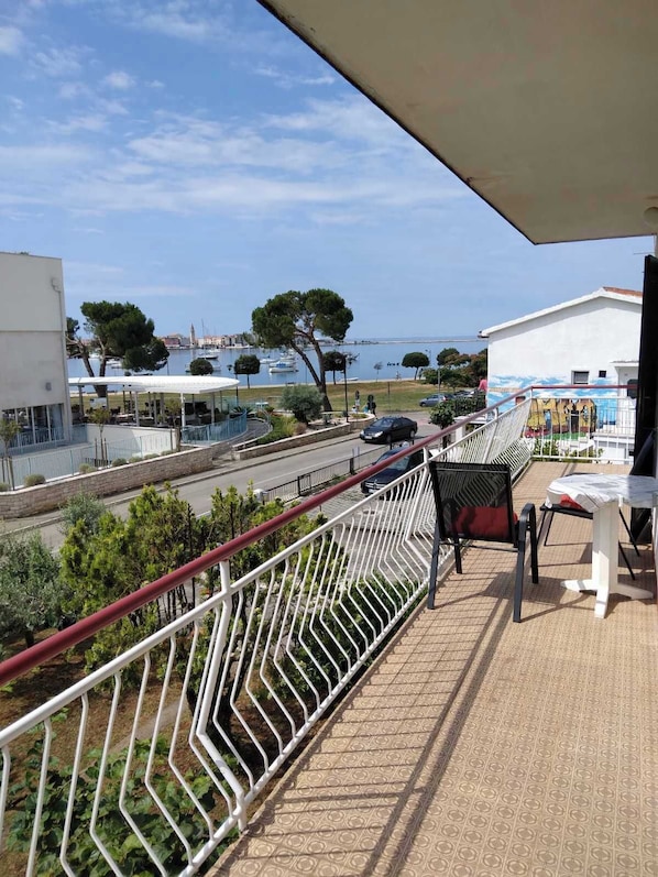A balcony with a view of the sea, a table with chairs, and a railing. - Apartment 2427/205552 (Istria - Umag), 700m from the beach (Umag)