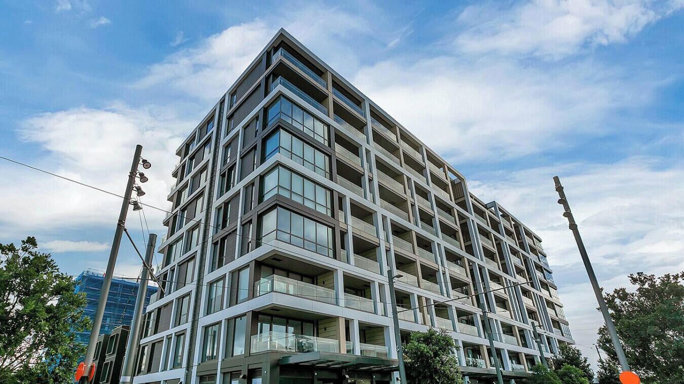 Un edificio a più piani con un design architettonico moderno, caratterizzato da un angolo in evidenza e ampie finestre.