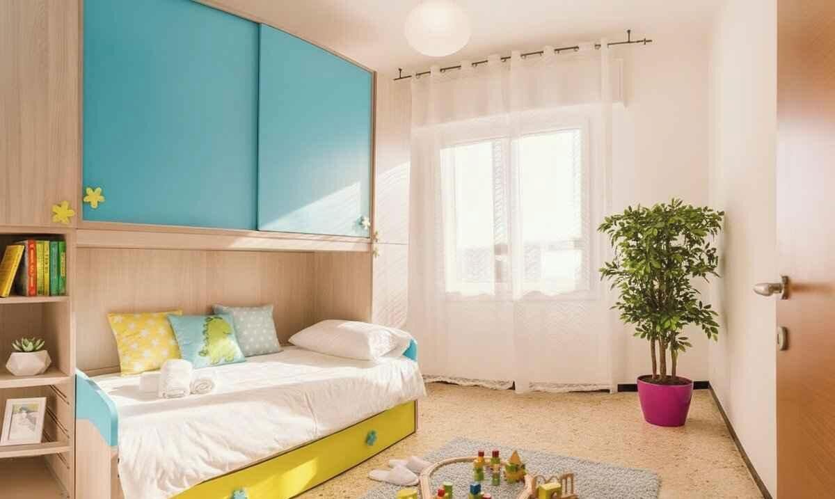 A bedroom with a bed, a bookshelf, a window with curtains, a potted plant, and a door.